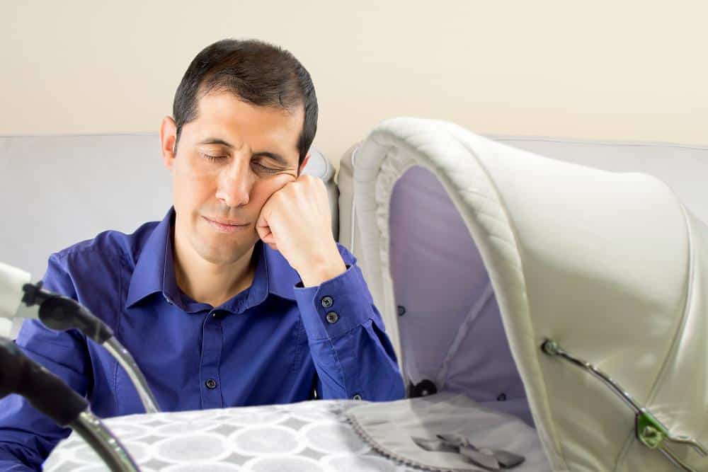 photo of a sleeping father near a stroller