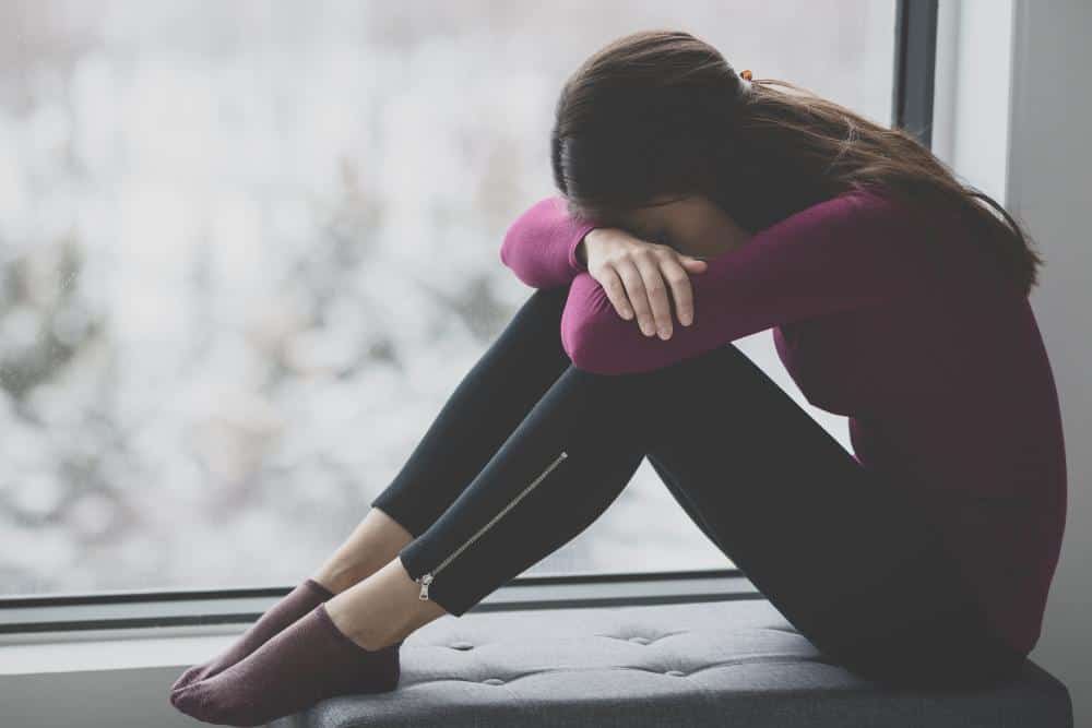 A girl sitting alone feeling upset