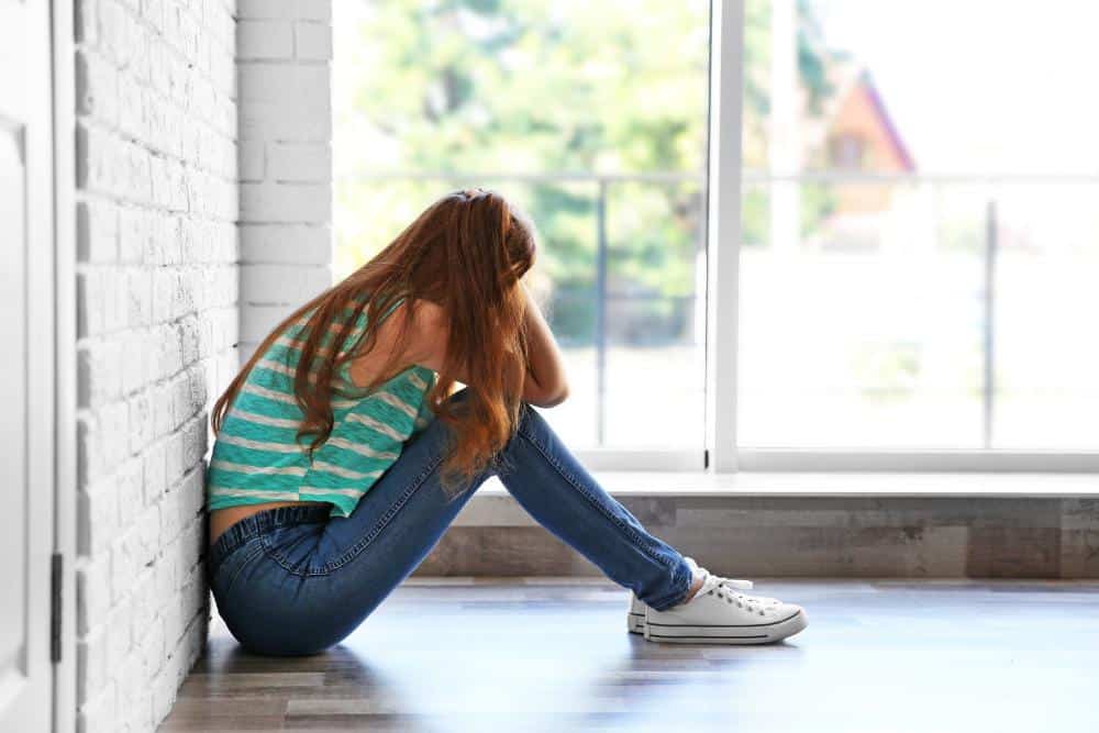 Antisocial Girl Sitting Against a Wall