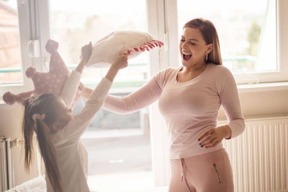 Child hitting adult with a pillow