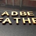 deadbeat father written with wooden letters on a black surface