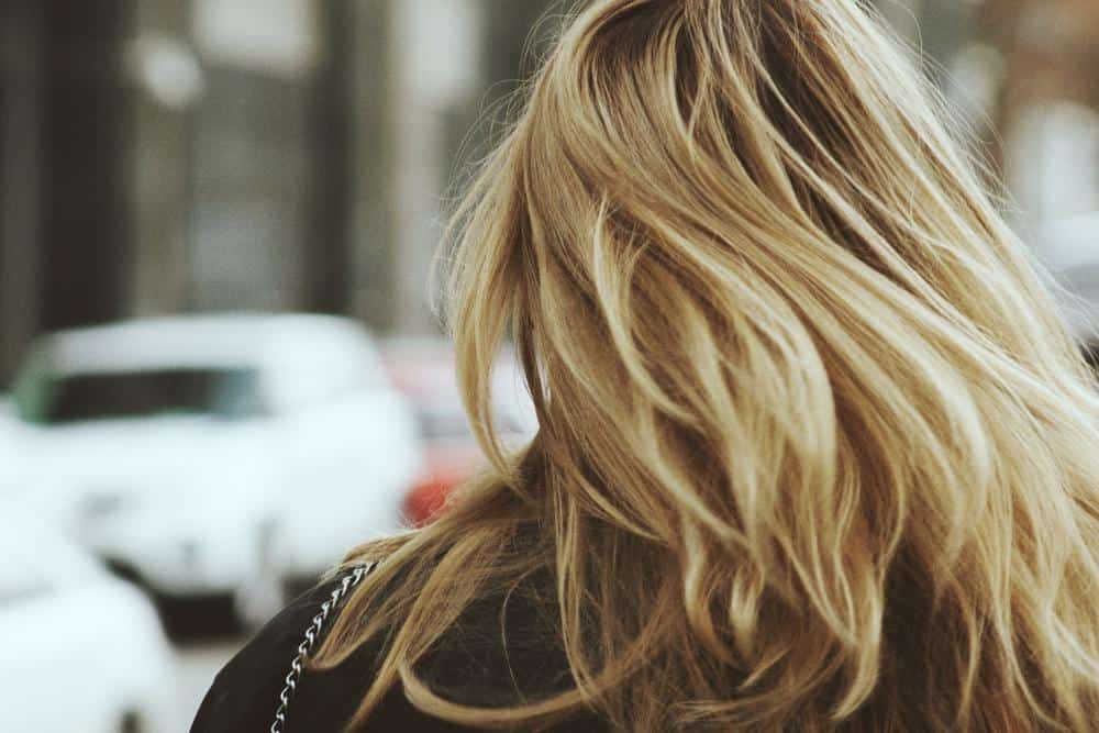 a blonde woman walking on the road