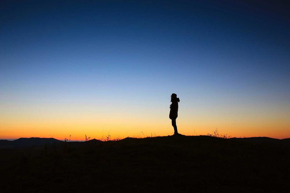 ilhouette of a person standing in the middle of nowhere