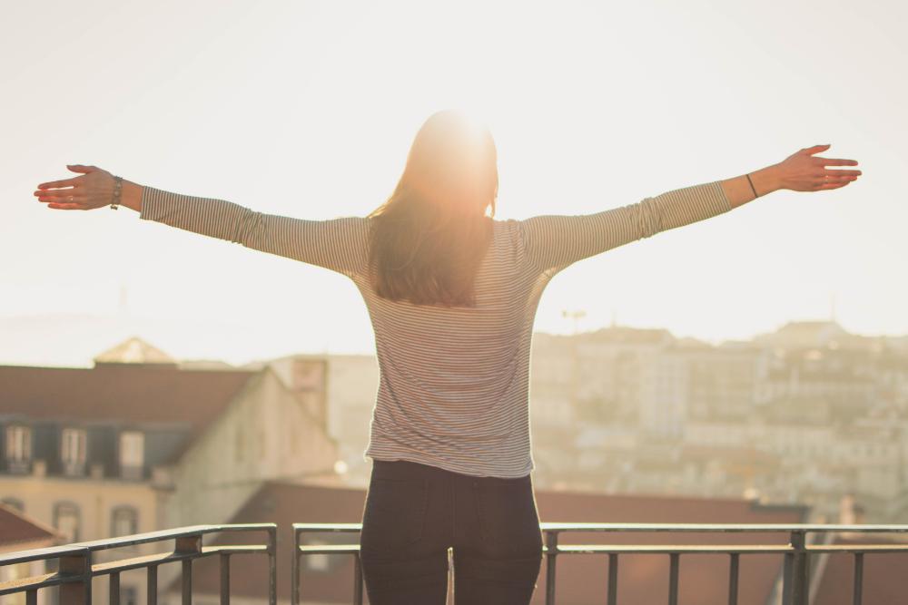 a woman standing with her arms wide open