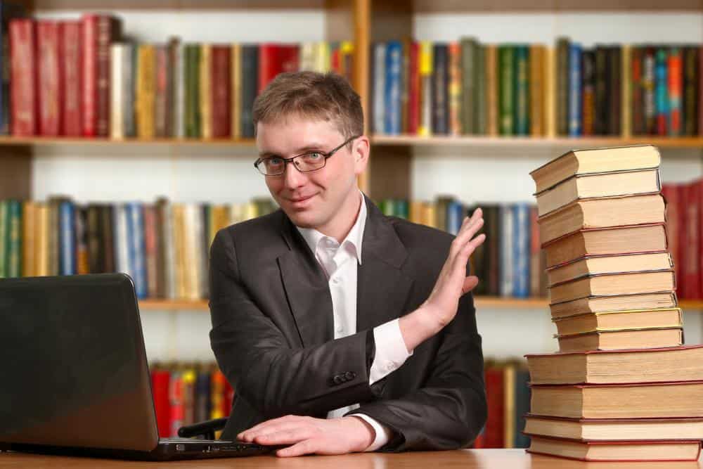 A clever student with books and a laptop