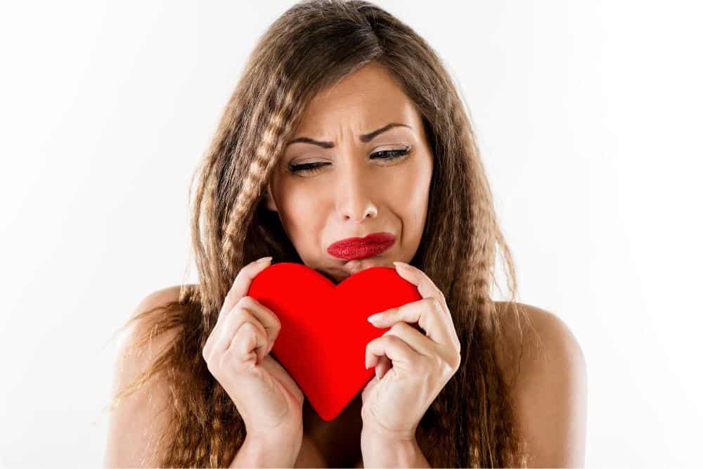 A woman crying with a heart in her hand