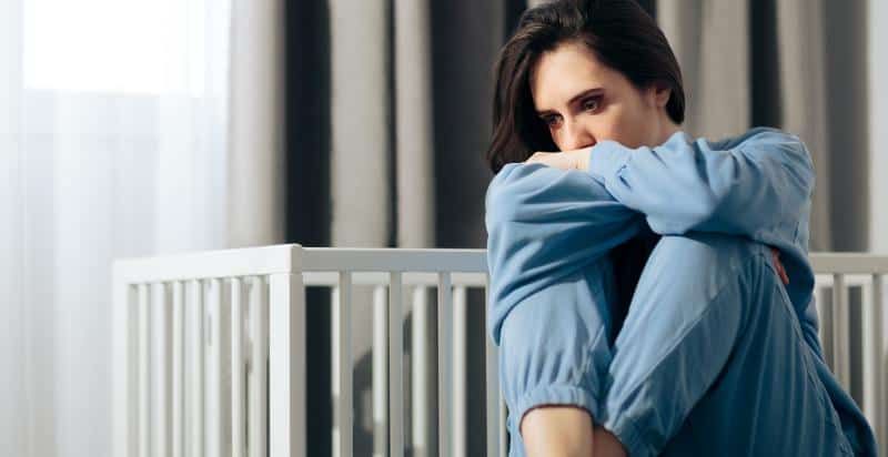 Depressed woman sitting in her room